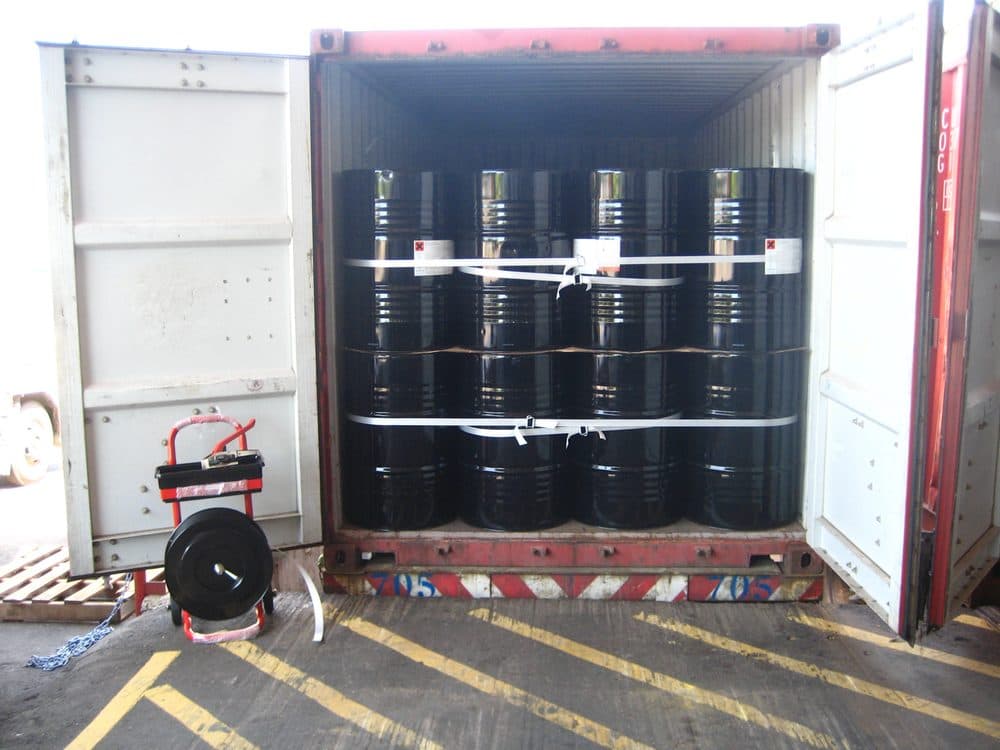 Drums secured inside a shipping container with lashing strap